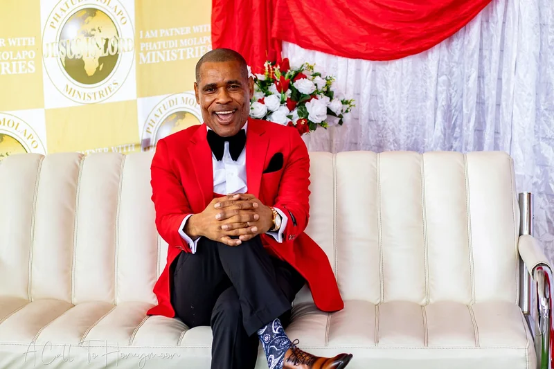 Pastor Phatudi Molapo seated in a red jacket at a ministry event