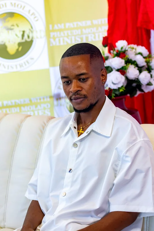 Young man seated at the ministry photo backdrop