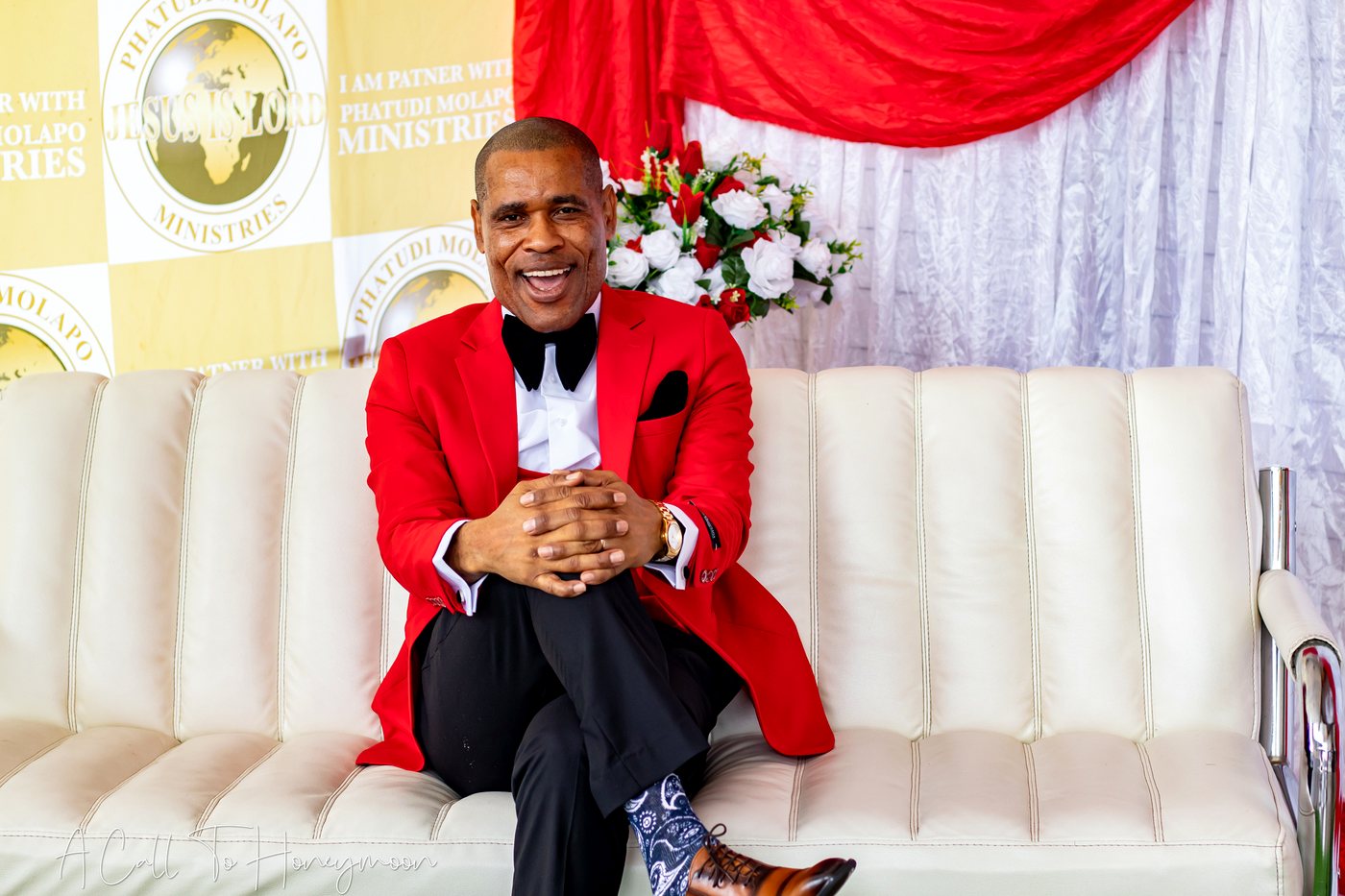 Pastor Phatudi Molapo seated in a red jacket at a ministry event