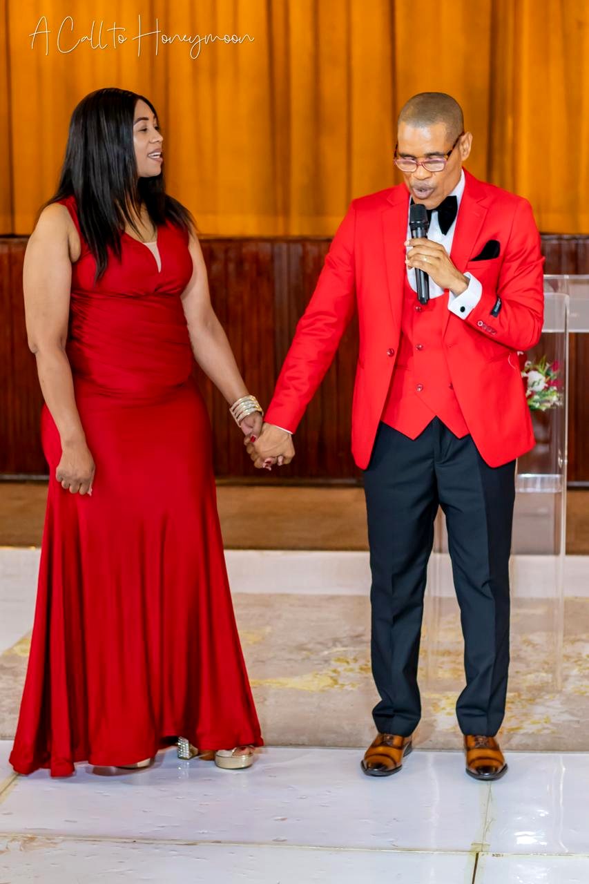 Pastor Phatudi Molapo praying with a woman in a red dress