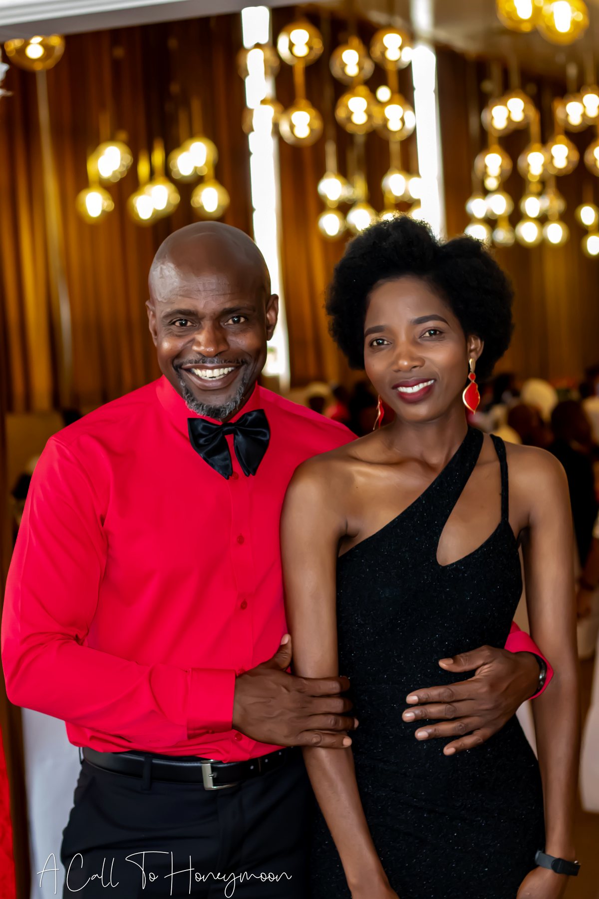 Pastor in red standing with a smiling woman at a ministry event
